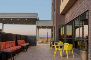 卡尔斯巴德Home2 Suites By Hilton Carlsbad New Mexico的大楼内带黄色桌椅的庭院