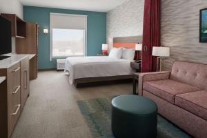 卡尔斯巴德Home2 Suites By Hilton Carlsbad New Mexico的酒店客房,配有床和沙发