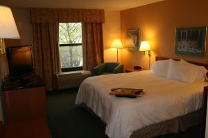 肖尼堪萨斯城/邵温米申汉普顿酒店的一间酒店客房,配有一张带托盘的床