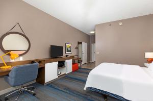 科尔宾科尔宾汉普顿酒店的酒店客房带一张床、一张书桌和一面镜子
