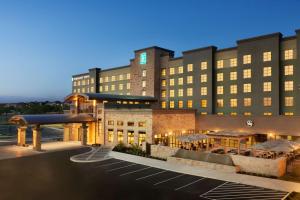 圣安东尼奥Embassy Suites San Antonio Brooks City Base Hotel & Spa的前面有一个停车位的酒店