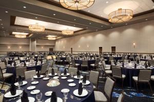 圣安东尼奥Embassy Suites San Antonio Brooks City Base Hotel & Spa的宴会厅配有桌椅和吊灯