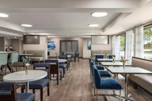 席勒公园芝加哥奥黑尔国际机场汉普顿酒店的一间配备有桌子和蓝色椅子的用餐室