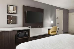 席勒公园芝加哥奥黑尔国际机场汉普顿酒店的酒店的客房,设有书桌和墙上的电视