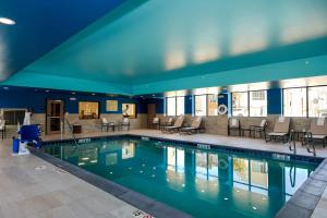 奥罗拉Hampton Inn & Suites Aurora South, Co的大楼内一个带桌椅的游泳池