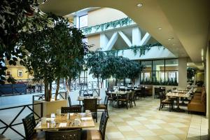 斯托克顿斯托顿希尔顿酒店的一间空餐厅,配有桌椅和树木