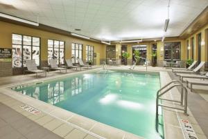 哥伦布哥伦布机场使馆套房酒店的游泳池位于酒店客房内,配有桌椅
