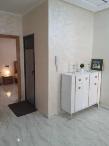 梅克内斯Appartement Dar Meknès的一间设有白色墙壁、橱柜和电话的房间