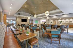 弗赖拉辛达拉斯弗里斯科希尔顿惠庭套房酒店的餐厅设有桌椅和沙发。