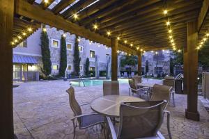 弗赖拉辛达拉斯弗里斯科希尔顿惠庭套房酒店的一个带桌椅的庭院和一个游泳池