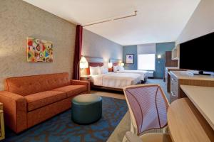 哈维Home2 Suites by Hilton Harvey New Orleans Westbank的酒店客房,配有床和沙发
