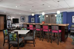 尼亚加拉瀑布尼亚加拉瀑布汉普顿酒店的餐厅设有酒吧,配有粉红色的椅子