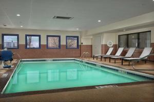 尼亚加拉瀑布尼亚加拉瀑布汉普顿酒店的一个带椅子的游泳池,一个坐在房间里的人