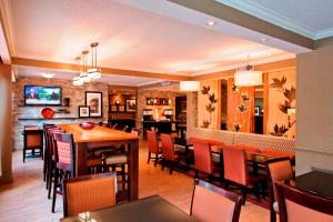 亚特兰大汉普顿亚特兰大诺斯莱克酒店的用餐室以及带桌椅的厨房。