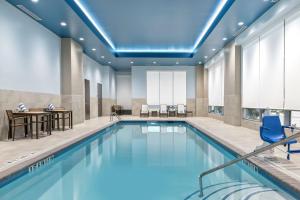 大学城Embassy Suites By Hilton College Station的一个带桌椅的酒店客房的游泳池