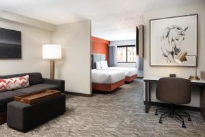 达拉斯达拉斯市区/西端万豪春季山丘套房酒店的酒店客房设有沙发、床和书桌