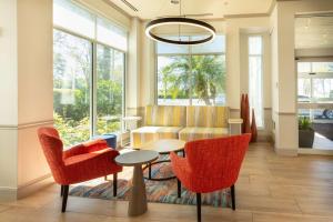 代托纳海滩代托纳比奇机场希尔顿花园酒店的客厅配有桌椅和沙发