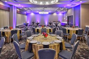 小石城Hilton Garden Inn Little Rock Downtown的一个带桌椅和紫色照明的宴会厅