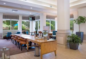 岩石丘希尔顿花园石山酒店的用餐室设有桌椅和窗户。