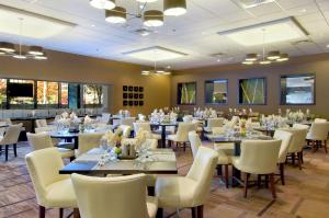 圣路易斯圣路易斯球场希尔顿酒店的大型用餐室配有桌子和白色椅子
