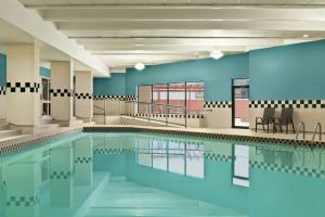 萨斯卡通萨斯卡通中心希尔顿花园酒店的一个带蓝色墙壁和椅子的大型游泳池