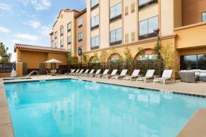 隆波克加州隆波克希尔顿花园酒店 的一座带躺椅的游泳池和一座建筑
