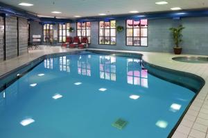 布卢明顿布卢明顿希尔顿逸林酒店的大楼内的一个蓝色海水游泳池