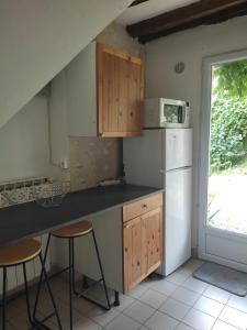 Vulaines-sur-SeineLes Glycines的厨房配有柜台和2把凳子