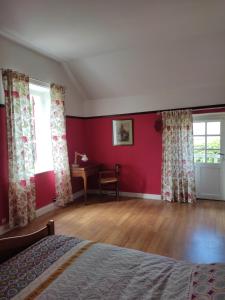 Vulaines-sur-SeineLes Glycines的一间卧室设有红色的墙壁、一张床和一张书桌