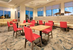 福特希尔兰赫东艾尔文/森林湖希尔顿花园酒店的餐厅设有红色的椅子和桌子以及窗户。