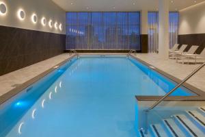 蒙特利尔Hilton Garden Inn Montreal Midtown, Quebec, Canada的蓝色的大游泳池,位于酒店客房内