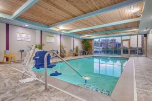 印第安纳波利斯Home 2 Suites By Hilton Indianapolis Northwest的游泳池,位于酒店带健身房的房间内