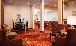 温尼伯温尼伯机场 - 马球公园希尔顿惠庭套房酒店的酒店大堂设有带桌椅的餐厅