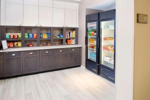 兰开斯特Homewood Suites Lancaster的厨房配有深色木质橱柜和开放式冰箱。
