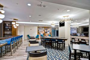 布鲁克林Homewood Suites by Hilton Boston Brookline-Longwood Medical的一间带桌椅的餐厅和一间酒吧