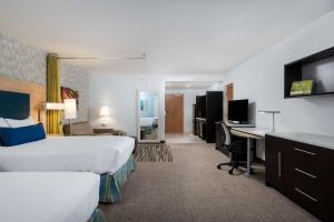 达尼亚滩Home2 Suites By Hilton Ft. Lauderdale Airport-Cruise Port的酒店客房设有一张大床和一张书桌。