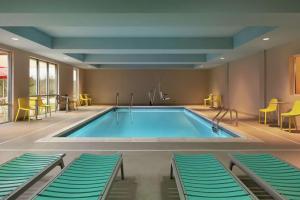 尚蒂伊Home2 Suites By Hilton Chantilly Dulles Airport的游泳池位于酒店带椅子的房间内