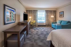 扬克斯扬克斯汉普顿酒店 - 威彻斯特的酒店客房配有一张床、一张书桌和一台电视。
