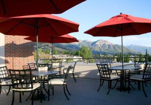 盐湖城盐湖城大学岳麓大道汉普顿套房酒店的一个带桌椅和红伞的庭院