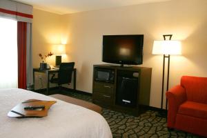 盐湖城盐湖城大学岳麓大道汉普顿套房酒店的配有一张床和一台平面电视的酒店客房