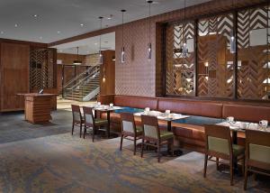 里贾纳里贾纳希尔顿逸林酒店及会议中心的一间带桌椅的餐厅,以及楼梯