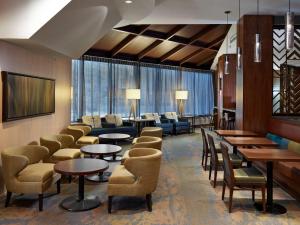 里贾纳里贾纳希尔顿逸林酒店及会议中心的一间设有桌椅和窗户的等候室