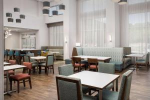 列克星敦Hampton Inn & Suites Lexington的用餐室设有桌椅和窗户。