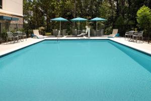 列克星敦Hampton Inn & Suites Lexington的一个带椅子和遮阳伞的大型蓝色游泳池