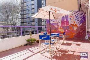 马德普拉塔Barcelona Hostel的屋顶上的桌椅和雨伞