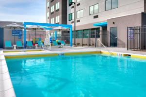 圣乔治Tru By Hilton St. George的一个带蓝色椅子和遮阳伞的大型游泳池