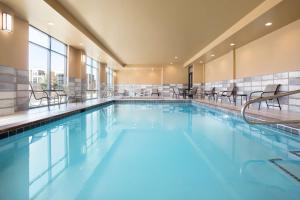 HolladayHampton Inn Salt Lake City Cottonwood的大楼内带椅子的大型游泳池