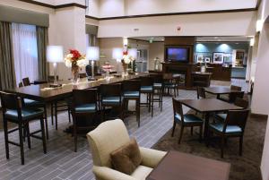 Suisun City萨斯城河岸汉普顿酒店及套房的一间带桌椅和电视的餐厅