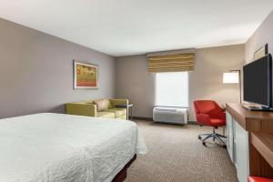 雅典阿森斯汉普顿酒店 的酒店客房设有床、椅子和电视