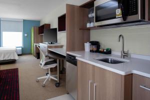 森特尼尔Home2 Suites By Hilton Denver South Centennial Airport的一个带水槽的厨房和一张书桌